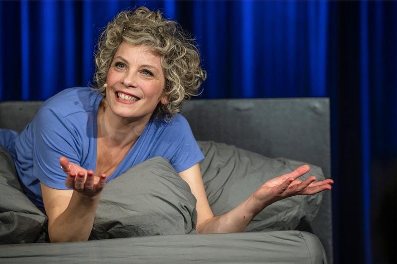 Eine Frau liegt auf einem Bett und unhält sich mit jemand